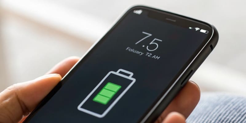 A person looking at a new electric car in a showroom with a thoughtful expression