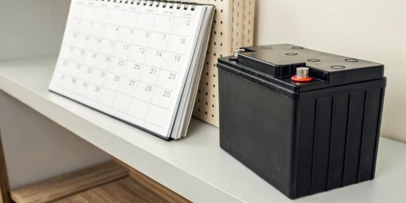 Black battery and calendar on desk