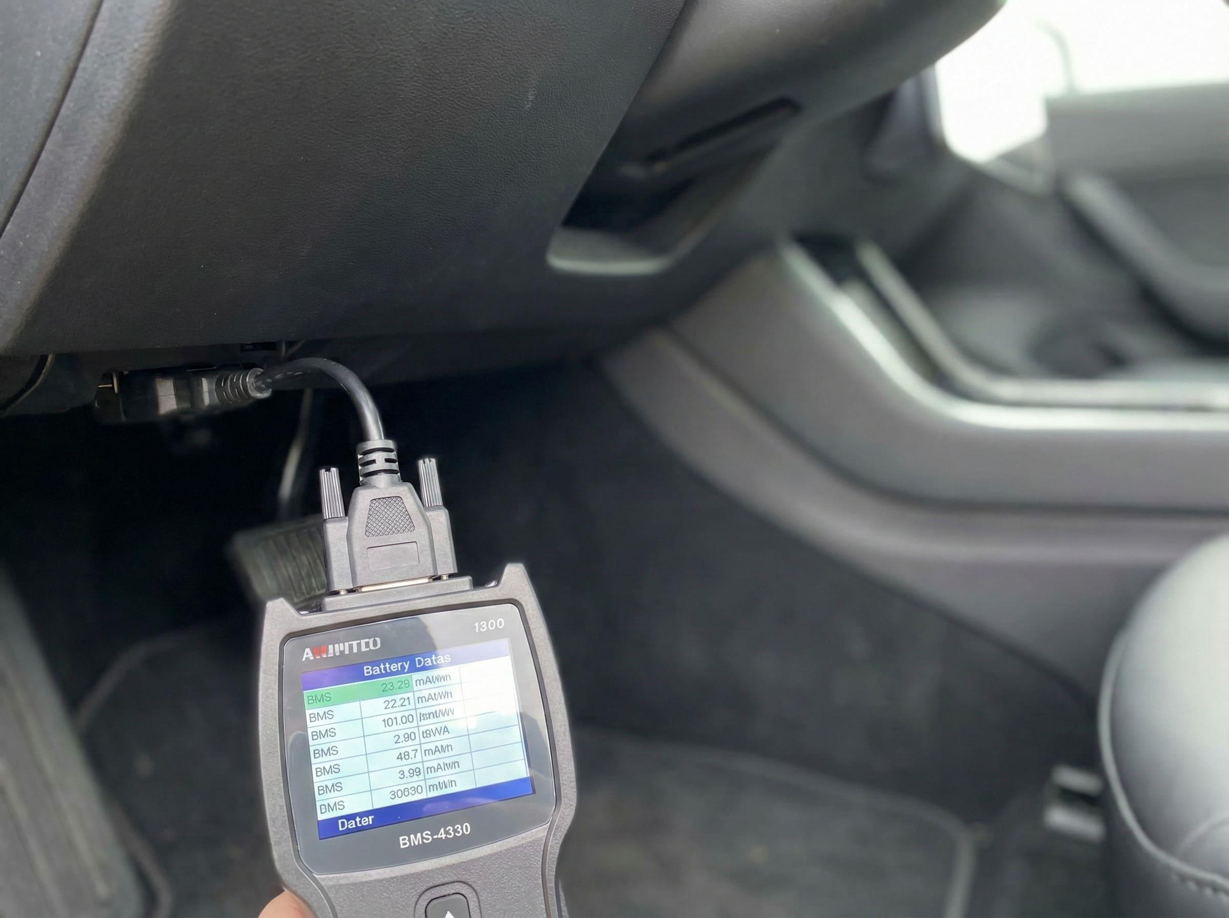 An OBD-II scanner plugged into a car's diagnostic port with data on a smartphone screen