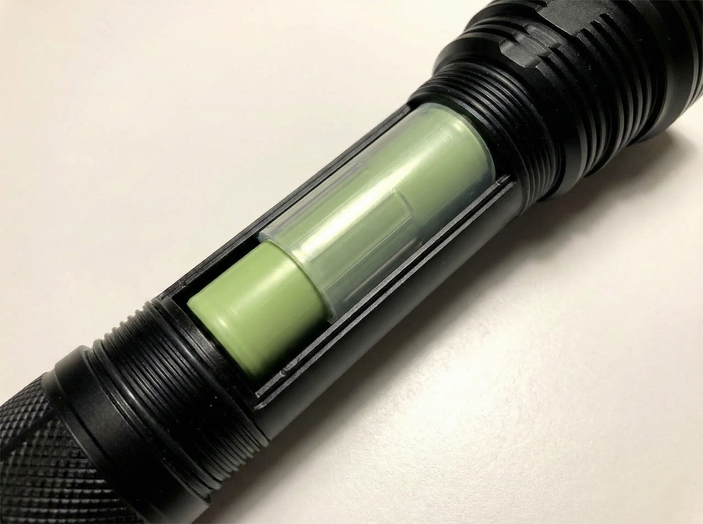 18650 Battery with 26650 Adapter A 18650 battery inside a plastic adapter sleeve next to a 26650 battery