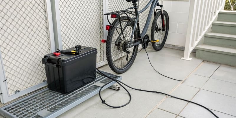 An e-bike battery being charged in a safe, well-ventilated area