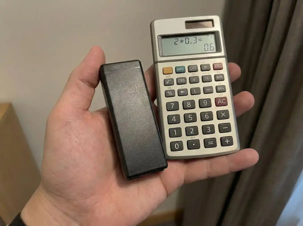 Holding black battery pack and calculator