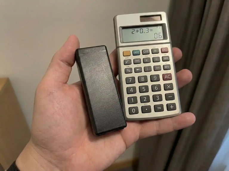 Holding black battery pack and calculator